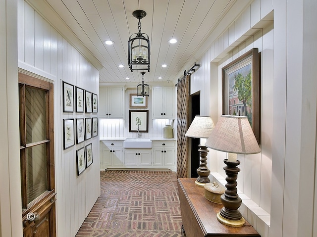 6528 Standing Boy Dr, Columbus, GA 31904 - corridor featuring a barn door, recessed lighting, brick floor, and a sink