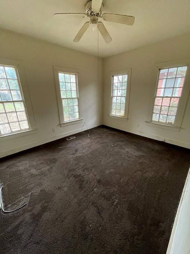 carpeted empty room featuring ceiling fan and a healthy amount of sunlight