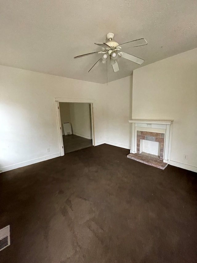 unfurnished living room with ceiling fan, dark carpet, and a textured ceiling