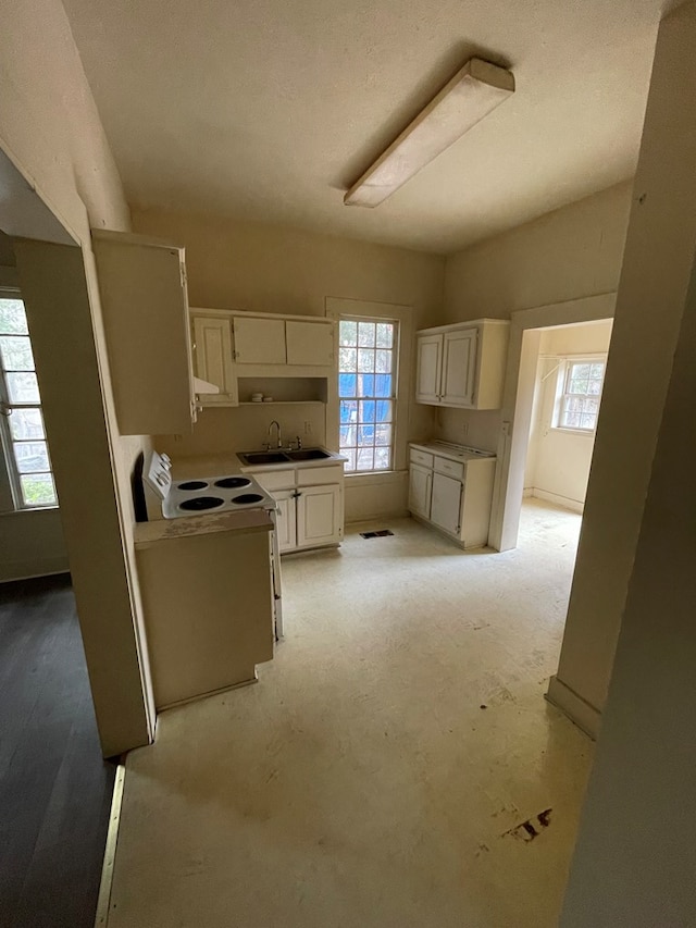 kitchen featuring sink, white cabinets, and white electric stove