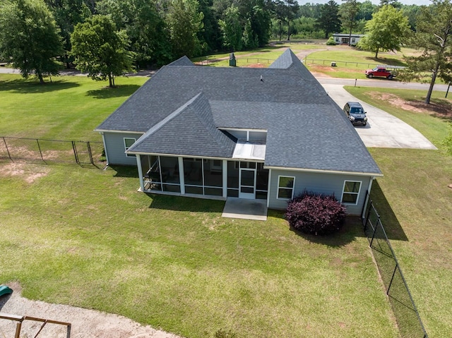 rear view of house with a sunroom and roof with shingles