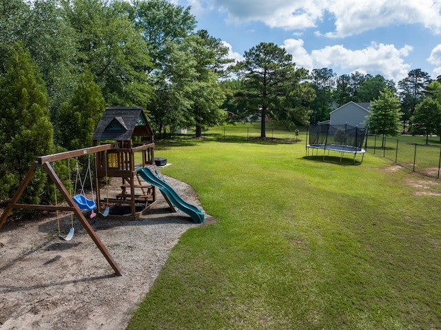 view of playground with a trampoline and view of wooded area