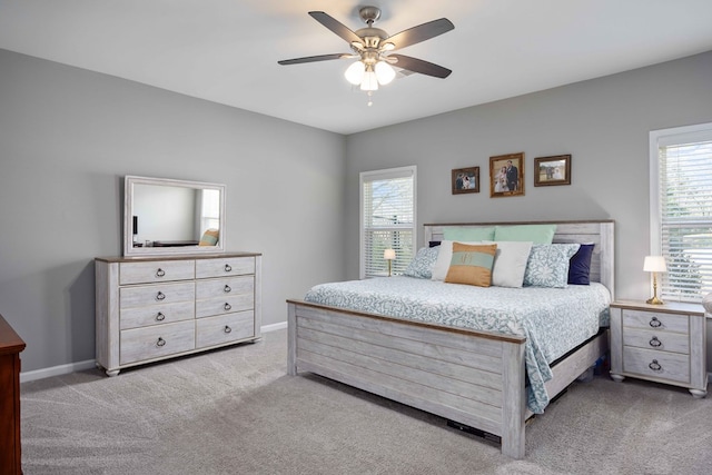bedroom featuring carpet flooring, multiple windows, ceiling fan, and baseboards