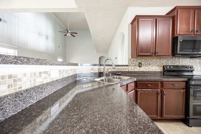 kitchen featuring range with two ovens, tasteful backsplash, a textured ceiling, and a sink