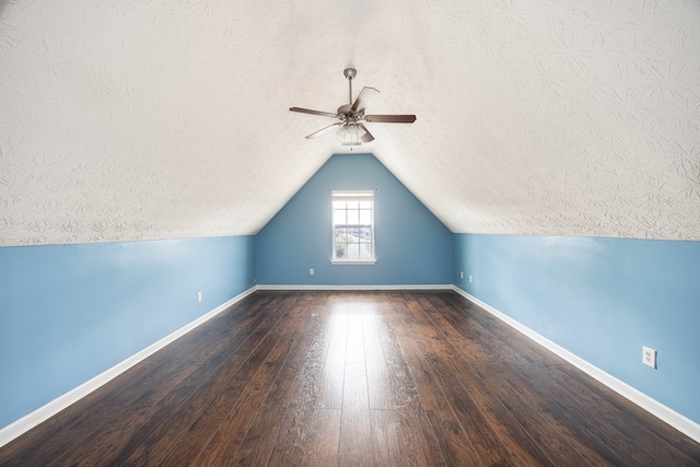 additional living space featuring baseboards, lofted ceiling, and hardwood / wood-style flooring