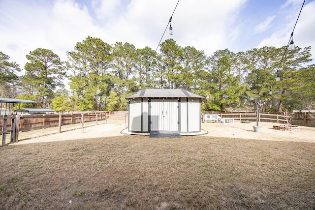 view of yard featuring an outbuilding, a storage shed, and a fenced backyard