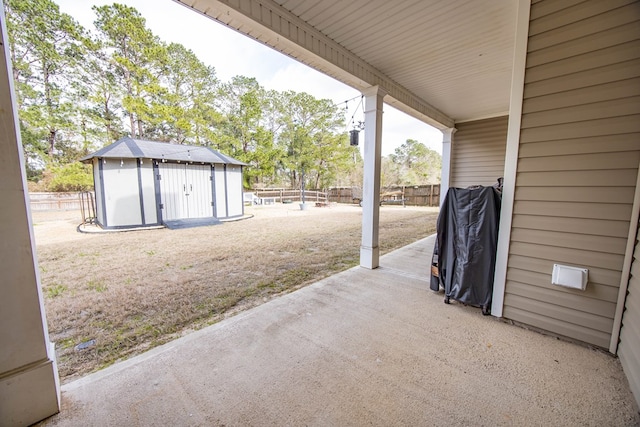 view of patio / terrace featuring a storage unit, an outdoor structure, and fence