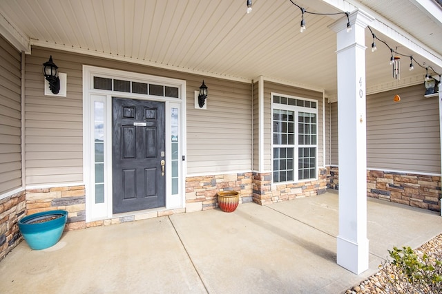 property entrance featuring a porch and stone siding