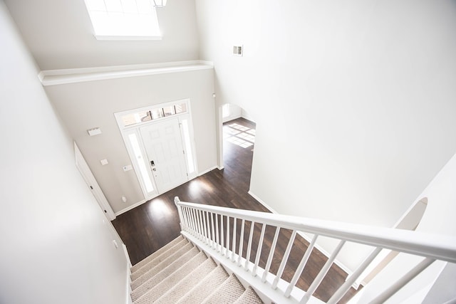 staircase featuring baseboards and wood finished floors