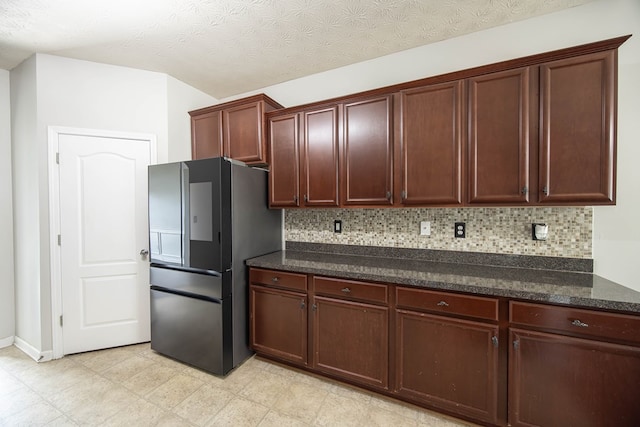 kitchen with dark stone counters, tasteful backsplash, smart refrigerator, and a textured ceiling