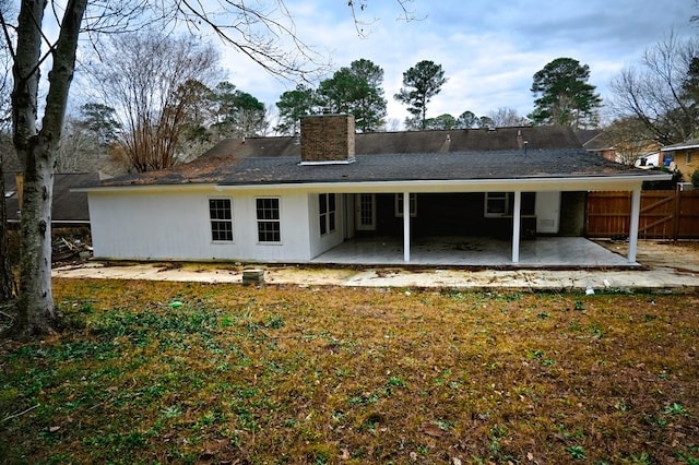 rear view of property with a yard and a patio