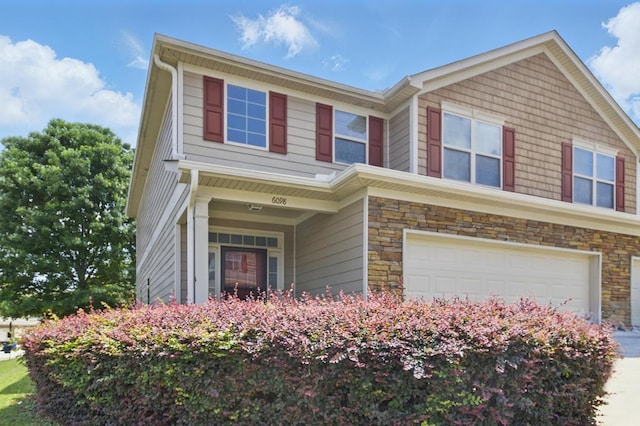 view of front of property with a garage, stone siding, and concrete driveway