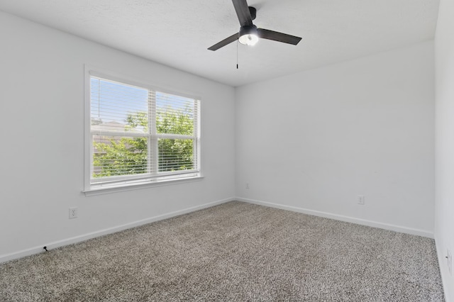 carpeted empty room featuring a ceiling fan and baseboards