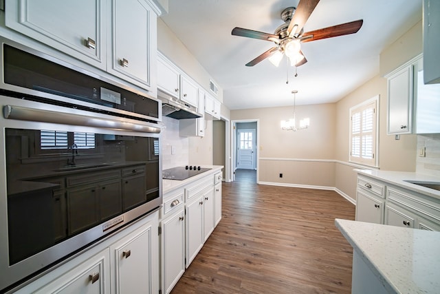 2310 Nottingham Dr, Columbus, GA 31904 - kitchen with stainless steel oven, decorative backsplash, ceiling fan, white cabinets, and dark wood finished floors