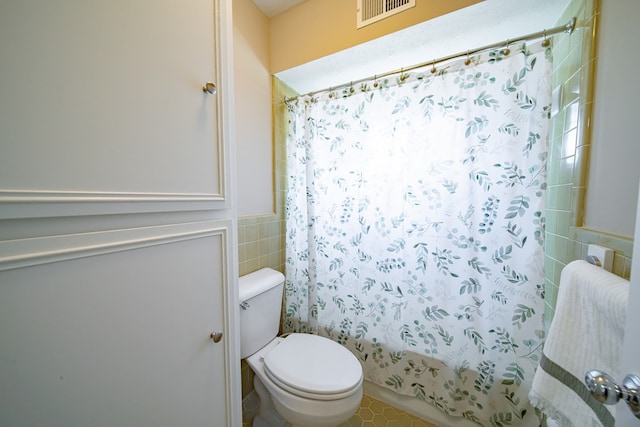 2310 Nottingham Dr, Columbus, GA 31904 - full bathroom featuring tile walls, toilet, and wainscoting