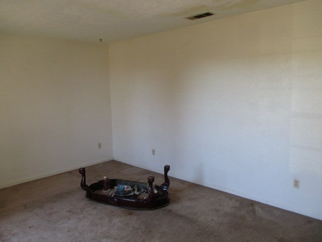 unfurnished room featuring carpet flooring and visible vents