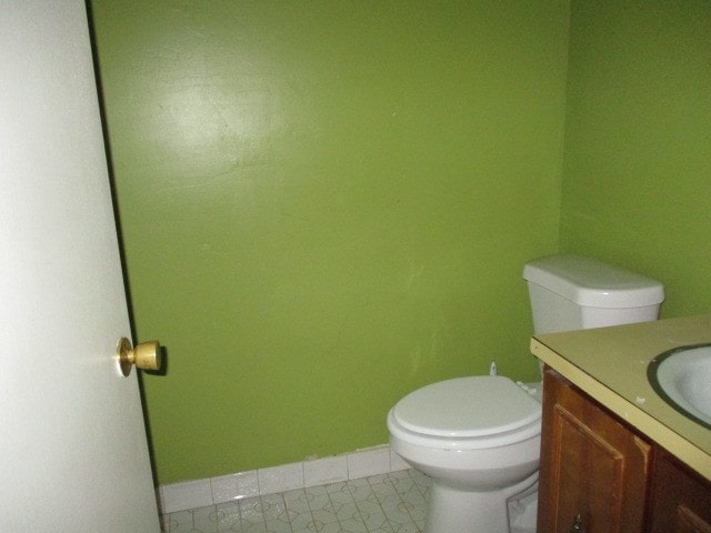 bathroom featuring vanity, toilet, and baseboards