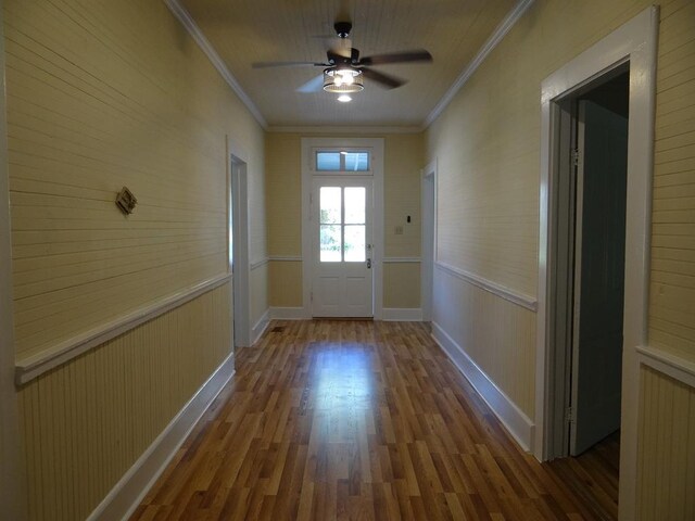 doorway featuring wood-type flooring, ceiling fan, and crown molding