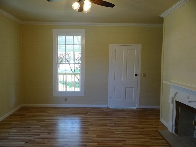 unfurnished living room with dark hardwood / wood-style flooring, ceiling fan, and ornamental molding