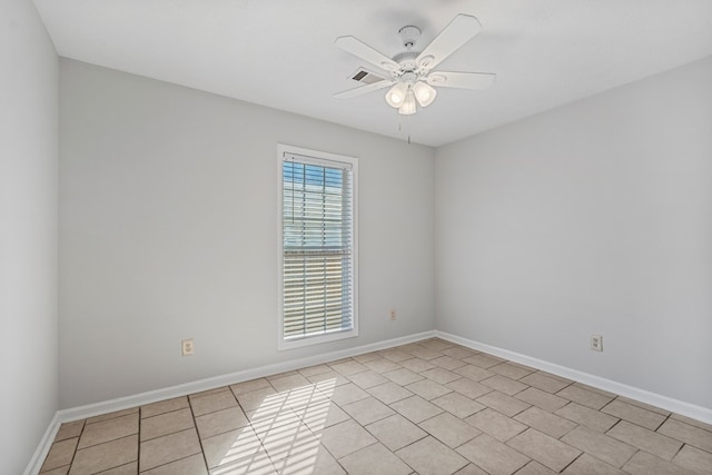 spare room featuring light tile patterned floors, a ceiling fan, and baseboards