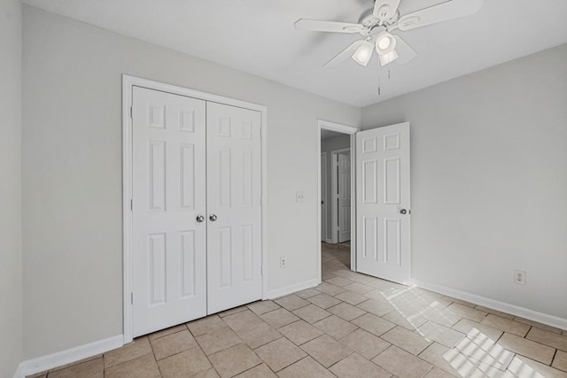 unfurnished bedroom featuring ceiling fan, light tile patterned floors, a closet, and baseboards