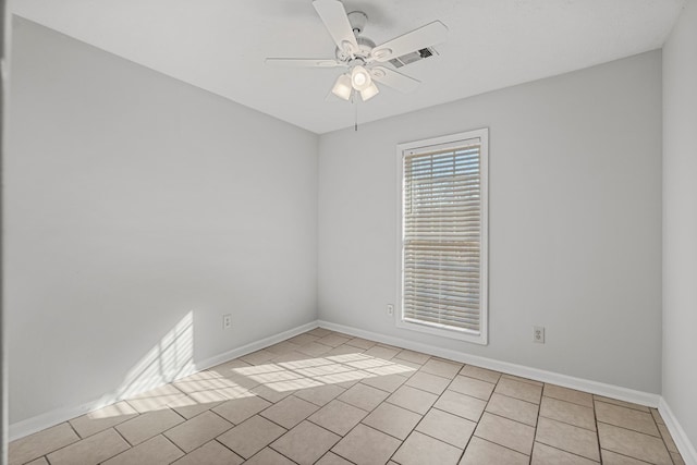 spare room featuring light tile patterned floors, ceiling fan, visible vents, and baseboards