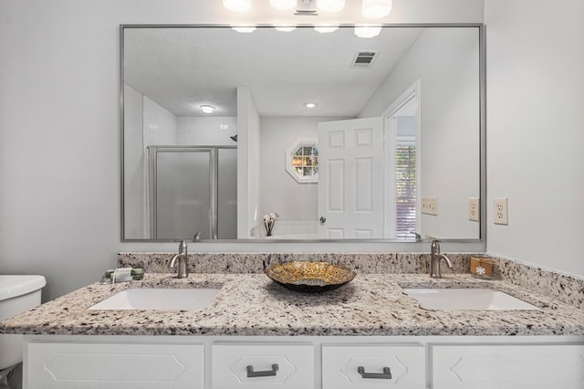 full bath with visible vents, a sink, a shower stall, and toilet