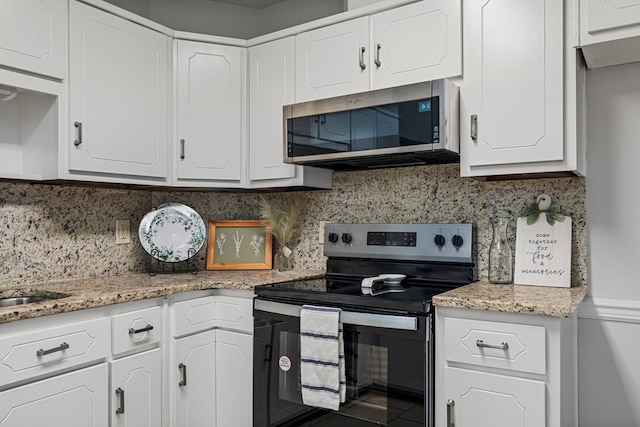 kitchen with stainless steel appliances, backsplash, and white cabinets