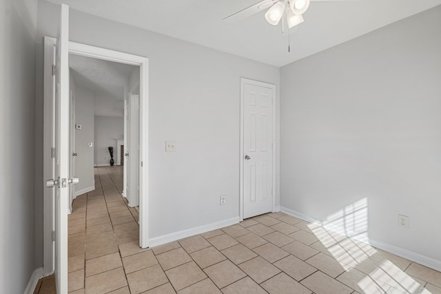 unfurnished room with light tile patterned floors, baseboards, and a ceiling fan