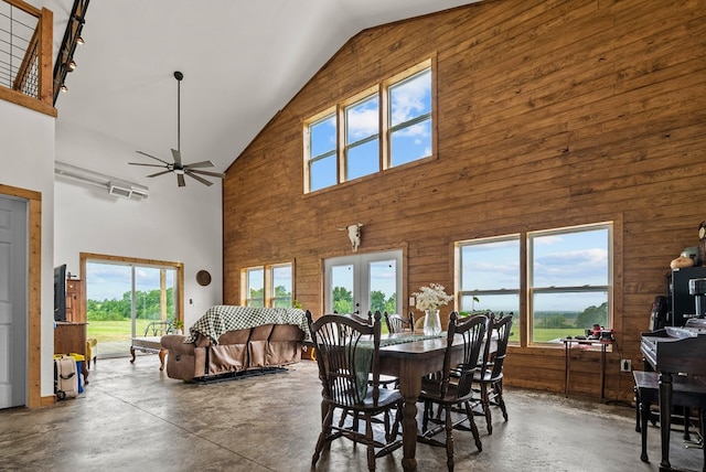 129 Hayes Rd, Mauk, GA 31058 - dining space featuring high vaulted ceiling, concrete flooring, wooden walls, healthy amount of natural light, and a ceiling fan