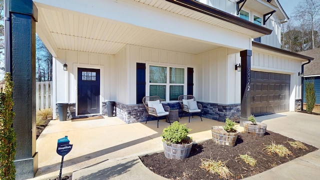 property entrance with stone siding, board and batten siding, and driveway