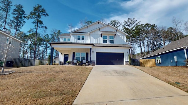 view of front facade featuring driveway, covered porch, fence, and board and batten siding