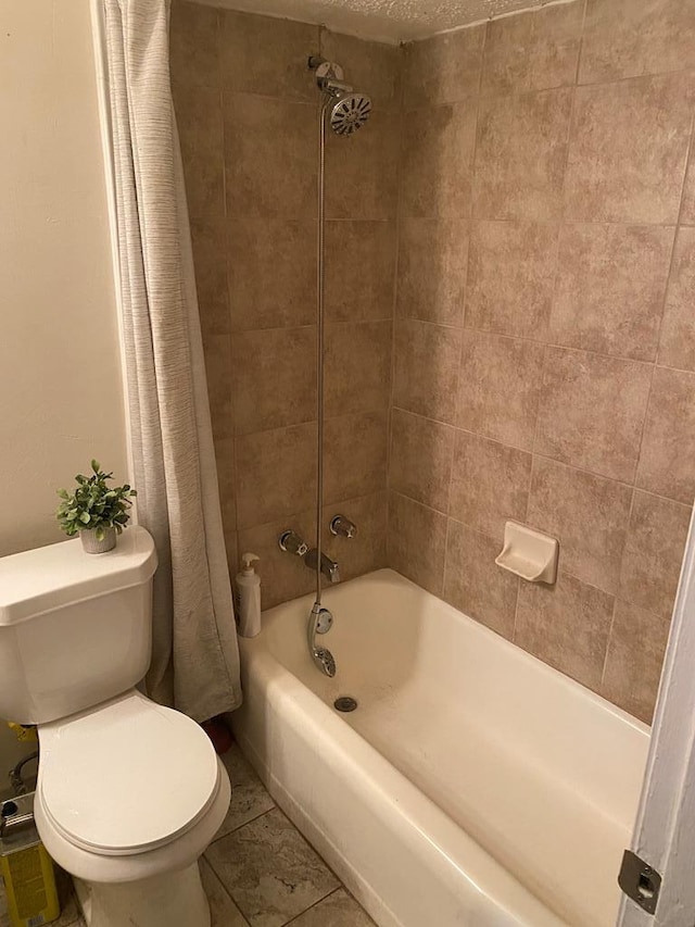 bathroom featuring tile patterned flooring, toilet, and shower / bathtub combination with curtain