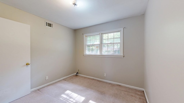 carpeted spare room featuring baseboards