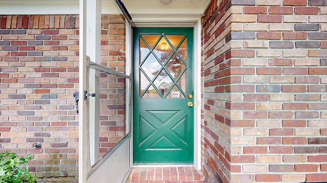 doorway to property with brick siding