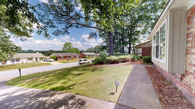 view of green lawn with a residential view