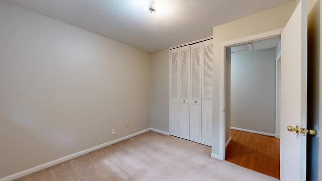 unfurnished bedroom with a closet, carpet floors, and baseboards