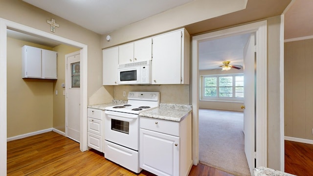 kitchen with white appliances, ceiling fan, light wood-style floors, and white cabinets