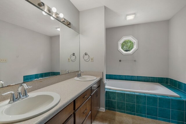 bathroom featuring vanity and tiled tub