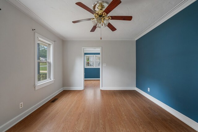 spare room featuring light hardwood / wood-style floors, ceiling fan, and crown molding