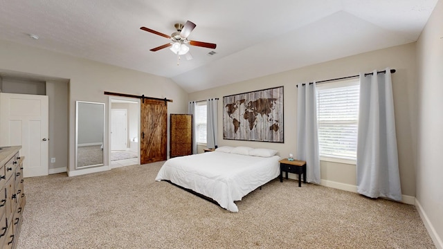bedroom with a barn door, baseboards, ceiling fan, light colored carpet, and vaulted ceiling