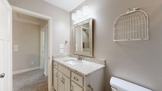 bathroom with vanity, toilet, and baseboards