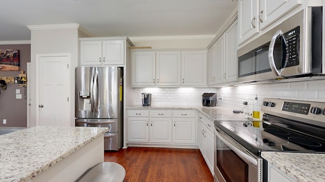 kitchen with tasteful backsplash, ornamental molding, dark wood finished floors, white cabinetry, and appliances with stainless steel finishes