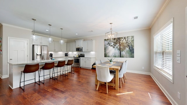 dining room with a chandelier, ornamental molding, and visible vents