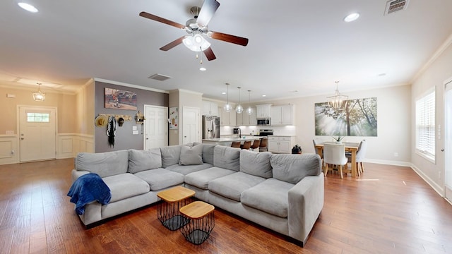 living room featuring crown molding, visible vents, hardwood / wood-style floors, and recessed lighting
