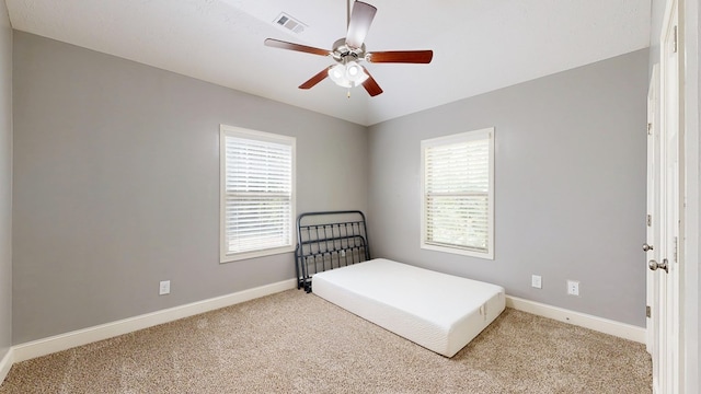 bedroom featuring baseboards, multiple windows, visible vents, and carpet