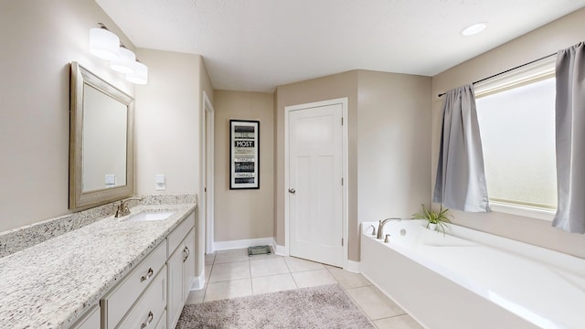 bathroom with vanity, baseboards, a bath, and tile patterned floors