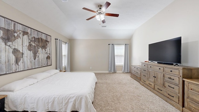bedroom with lofted ceiling, multiple windows, baseboards, and light colored carpet