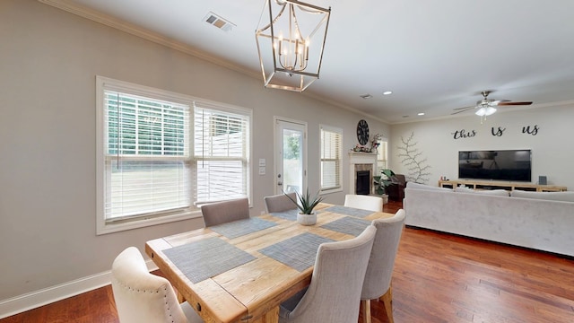 dining area featuring baseboards, crown molding, a fireplace, and visible vents