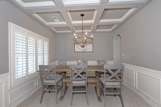 carpeted dining area with coffered ceiling, beam ceiling, and an inviting chandelier